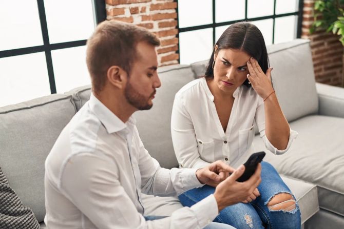 Mann zeigt skeptischer Frau sein Smartphone