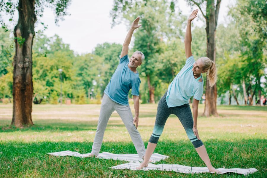Mann und Frau beim Sport im Freien, Yoga, Stretching