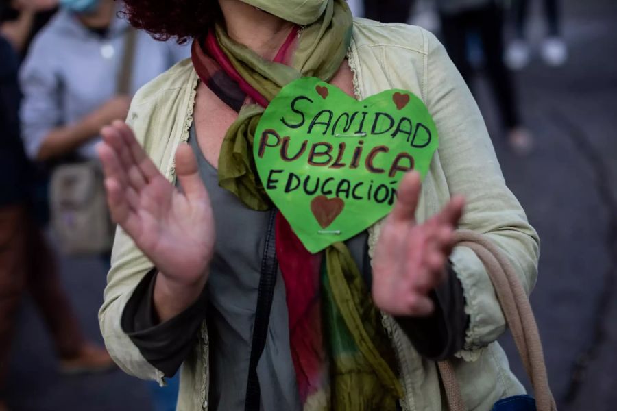 «Staatlicher Gesundheitsdienst - Bildung», steht in einem herzförmigen Aufkleber an einer Demonstrantin während eines Protests in einem der Wohngebiete, in dem neue Ausgangsbeschränkungen gegen die Ausbreitung des Coronavirus gelten.