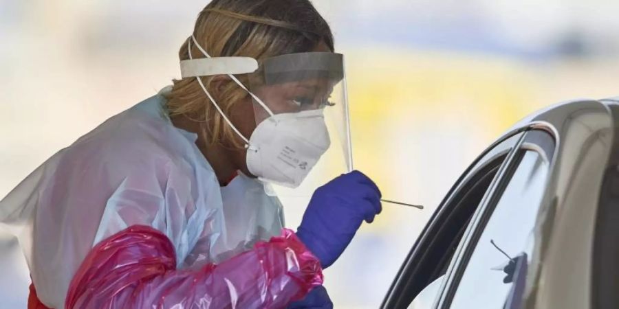 Eine Krankenschwester in Schutzanzug nimmt in Omaha einen Nasenabstrich von einem Patienten für einen Corona-Schnelltest. Foto: Nati Harnik/AP/dpa