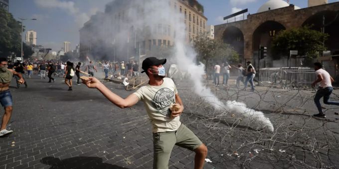 Ein Protestierender wirft Steine in Richtung der Sicherheitskräfte während eines Protests in Beirut. beirut proteste