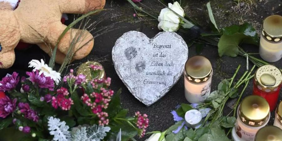 Kerzen und Blumen: Vor dem Haus fand eine kleine Trauerfeier statt. Foto: Roberto Pfeil/dpa
