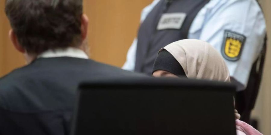 Die Angeklagte im Gerichtssaal des Oberlandesgerichts in Stammheim zwischen ihrem Anwalt (l.) und einem Mitarbeiter der Justiz (r). Foto: Marijan Murat
