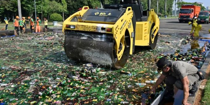Dampfwalze rollt über Flaschen mit Alkohol hinweg Dampfwalze rollt über Flaschen mit Alkohol hinweg