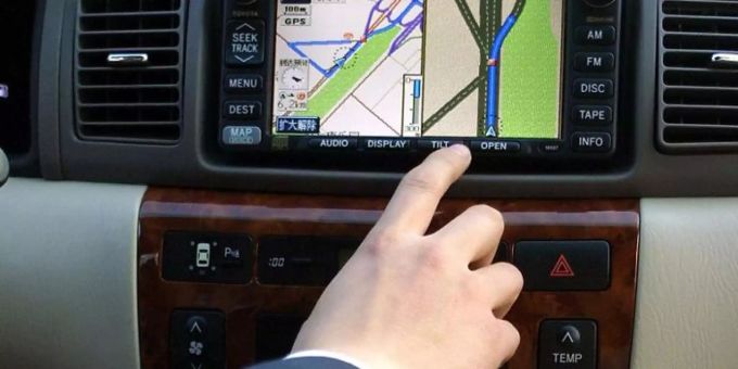 Ein Mann bedient ein Navigationsgerät. Navi