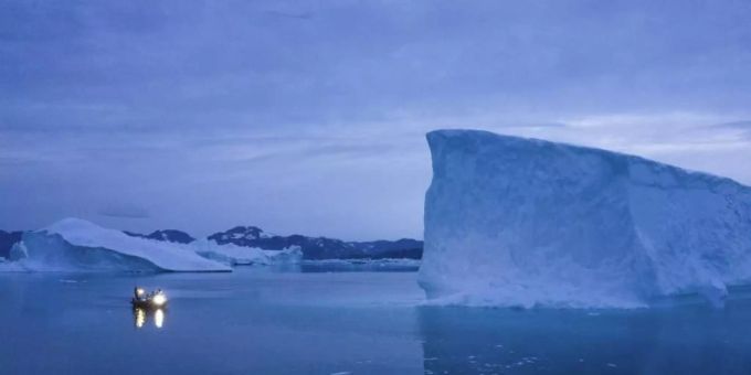 Ein Boot umfährt in der Dämmerung einen Eisberg auf Grönland. Foto: Felipe Dana/AP Ein Boot umfährt in der Dämmerung einen Eisberg auf Grönland. Foto: Felipe Dana/AP