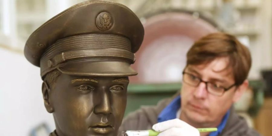 Der Techniker Michael Lenz streicht dem Prototypen des 3D-Kopfes Bronzefarbe auf. Foto: Roland Weihrauch