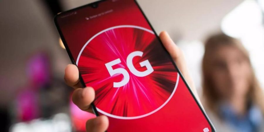 Eine Vodafone-Mitarbeiterin hält ein 5G-Smartphone in der Hand. Foto: Federico Gambarini