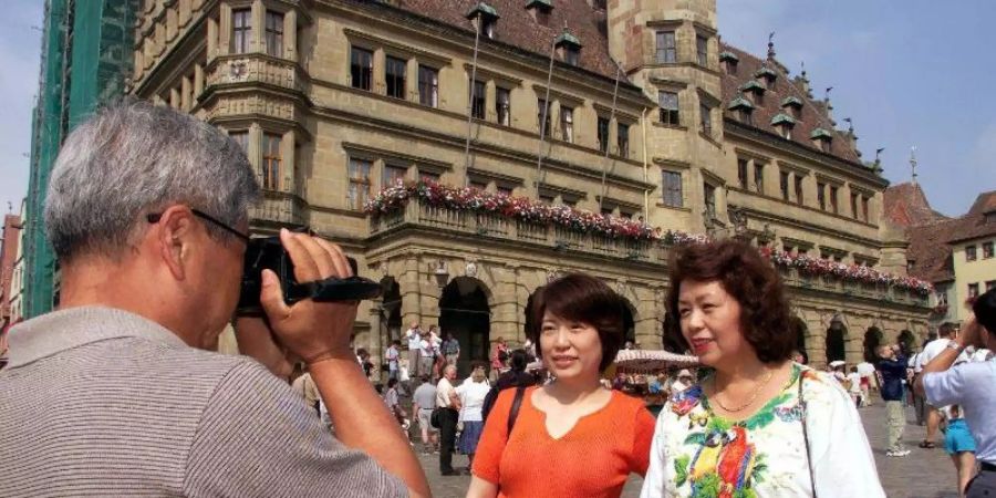 Japanische Touristen vor dem Renaissance-Rathaus in Rothenburg ob der Tauber. Foto: Stefan Kiefer