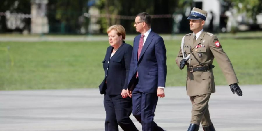 Merkel (l.) neben Morawiecki (M.) vor Beginn der Gedekfeier