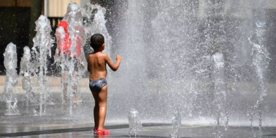 Hitzerekord erwartet: Ein Junge kühlt sich in einem Springbrunnen in Südfrankreich ab