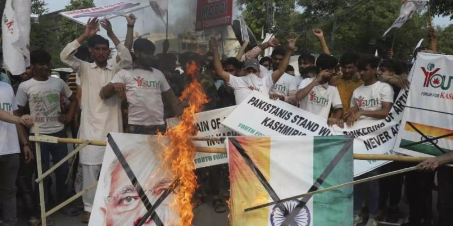 Pakistanische Demonstranten verbrennen bei einer Kundgebung in Lahore eine Fahne mit dem Bild des indischen Premierministers Modi. Foto: K.M. Chaudary/AP