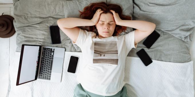 Ein Gefühl von konstanter Überforderung kann mit anderen Faktoren zu einem Burnout führen. Gestresste Frau