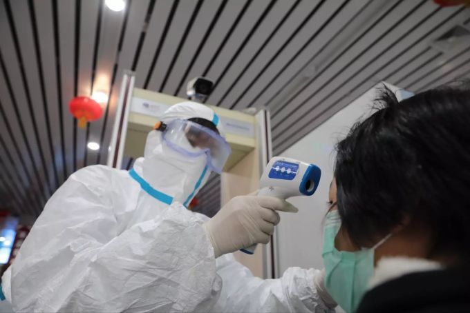 Der Sicherheitsinspektor Ma Lili misst die Körpertemperatur eines Passagiers am Bahnhof Lanzhou. Schweizer Firmen wei ABB treffen Massnahmen gegen den Coronavirus. Corona-Virus in China