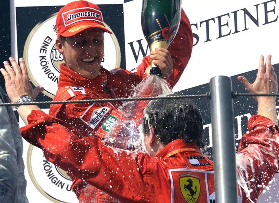 Michael Schumacher (l.) übergiesst Jean Todt mit seinem Sieges-Champagner.