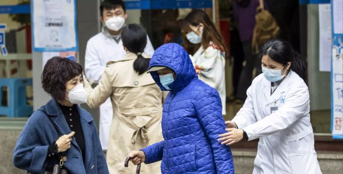 Mitarbeiter einer Apotheke in Guangzhou informieren Personen über das Coronavirus. coronavirus