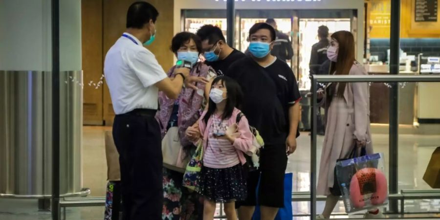 Menschen mit Atemschutzmasken am Hongkonger Flughafen