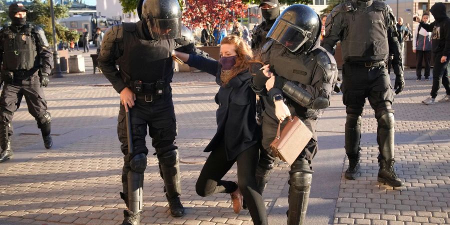 Russische Polizisten halten eine Demonstrantin fest während eines Protestes gegen die russische Teilmobilisierung in St. Petersburg.