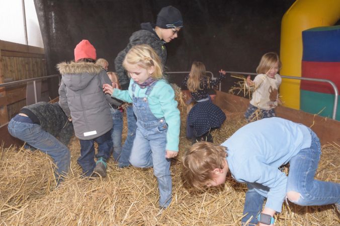 Nicht die Nadel, sondern den Kürbis im Heuhaufen suchen diese Kinder.
