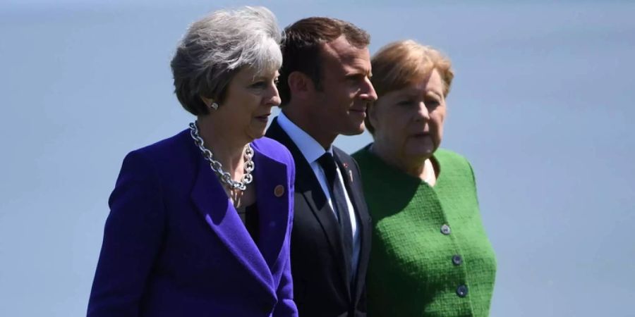 Grossbritanniens Premierministerin Theresa May (l.) und Frankreichs Präsident Emmanuel Macron (m.) zusammen mit der deutschen Bundeskanzlerin Angela Merkel (r.) beim G7-Gipfel im Juni in Kanada.