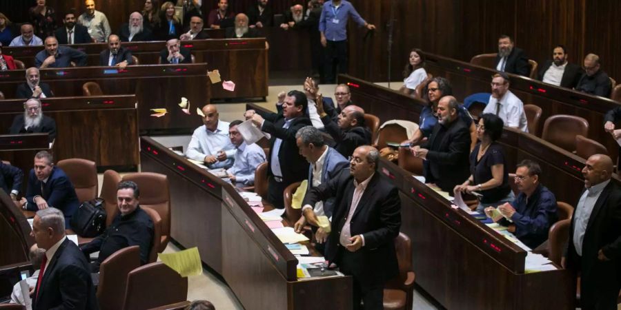 Arabische Abgeordnete stehen aus Protest während einer Parlamentssitzung in Israel von ihren Plätzen auf. Nach langen Debatten hat Israels Parlament ein umstrittenes Gesetz verabschiedet, das den jüdischen Charakter des Landes stärken soll.