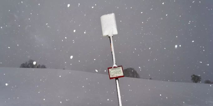 Bayern ist in Schnee gehüllt: Der Verkehr ist eingeschränkt, die Schulen sind geschlossen. Ein mit Schnee bedecktes Schild an einer Bushaltestelle.