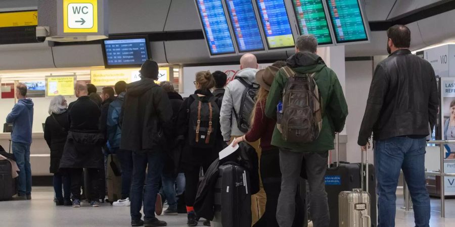 Reisende warten an einem Schalter am Flughafen Tegel.