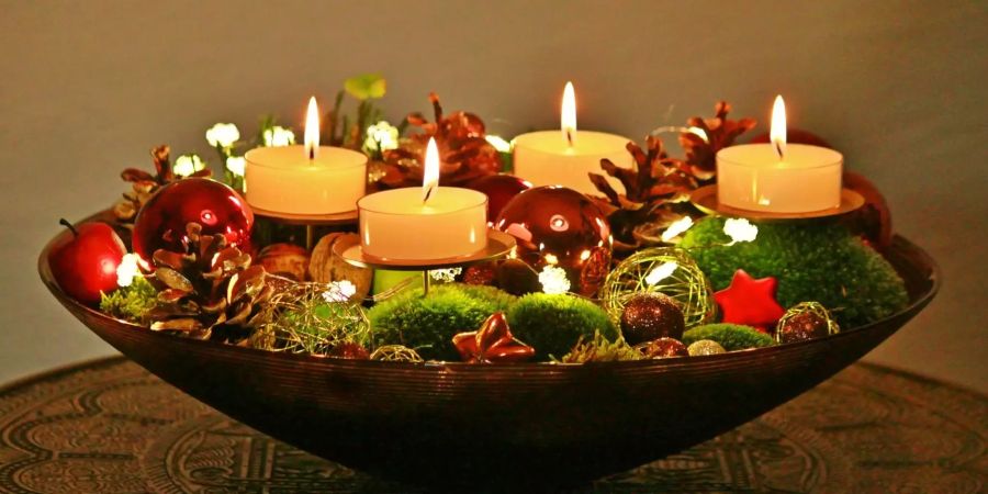 Ein Adventskranz mit vier brennenden Kerzen.