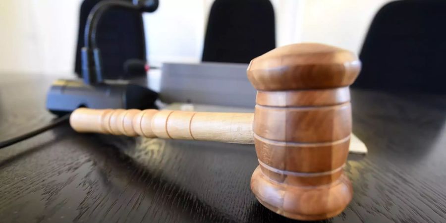 Auf der Richterbank liegt am ein Richterhammer aus Holz.