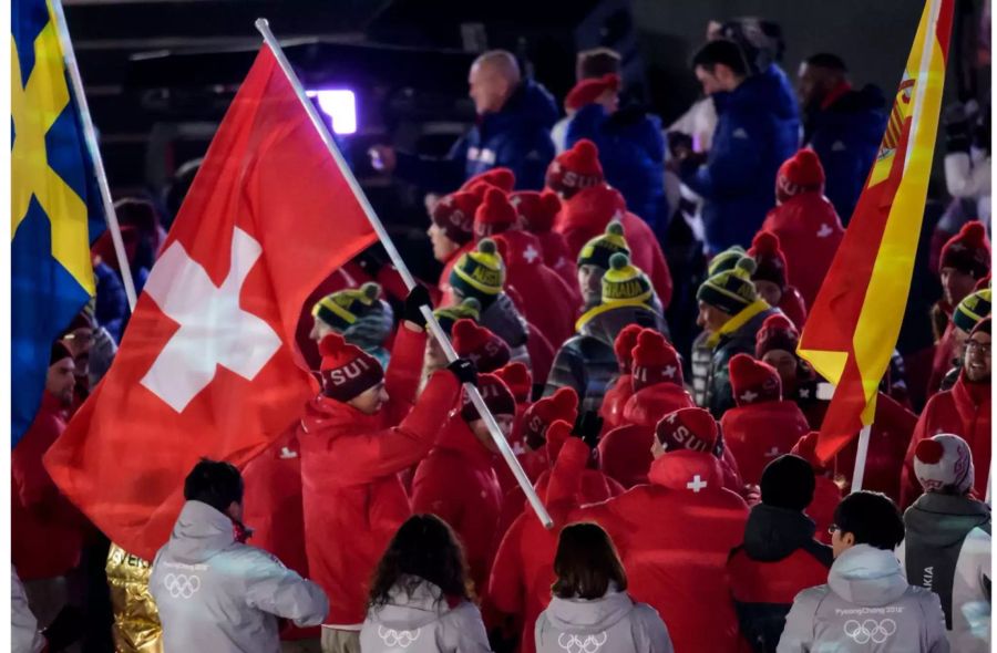 Fahnenträger Ramon Zenhäusern führt die Schweizer Delegation an.