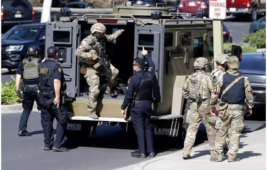 Schwer bewaffnete Polizisten steigen aus einem Panzerfahrzeug.