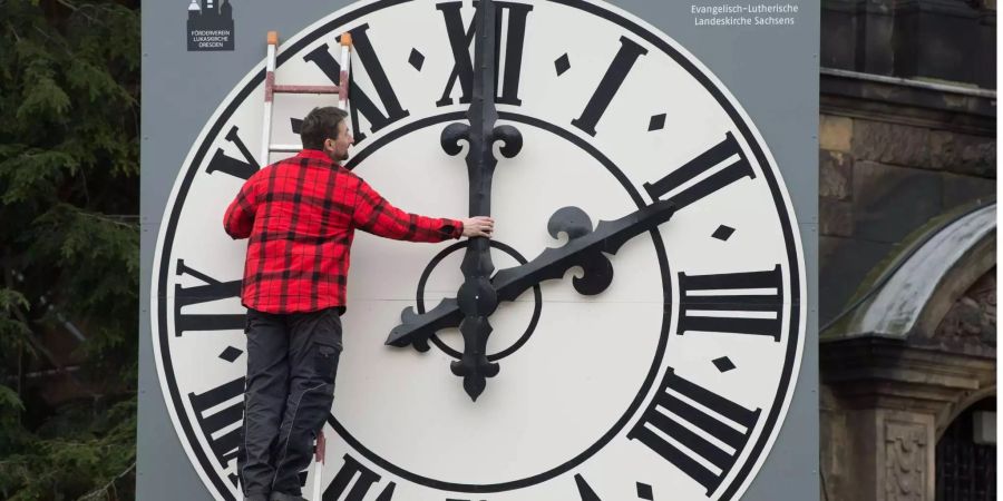 Ein Uhrentechniker kontrolliert die Mechanik der Zeiger der Kirchturmuhr der Dresdner (D) Lukaskirche.