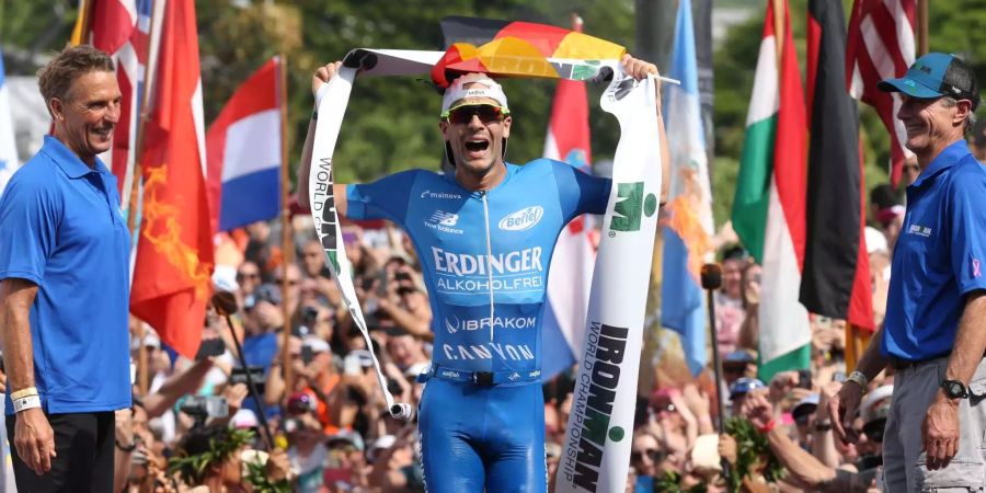 Patrick Lange aus Deutschland jubelt beim Ironman World Championship Triathlon über seinen Sieg.