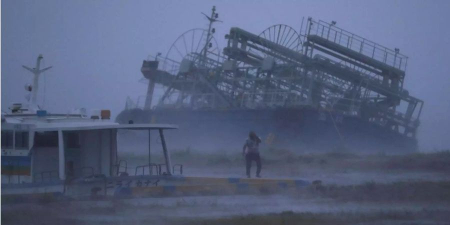 Ein Schiff wird im Hafen von Yonabaru an Land gespült, während sich Taifun «Trami» der Küste nähert.