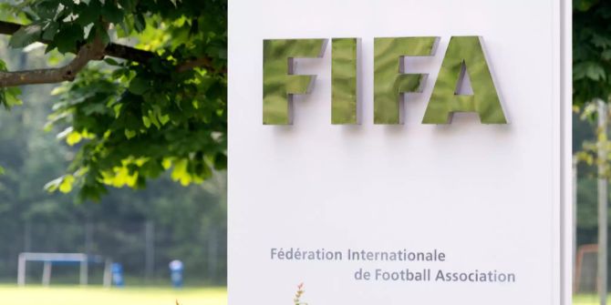 Das FIFA Logo auf einer Einrichtung vor einem Sportplatz