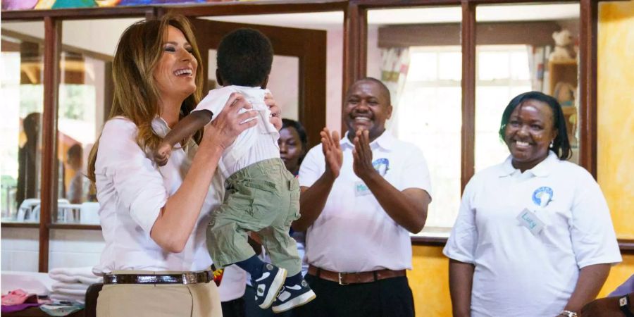 US-First Lady Melania Trump hebt ein Baby während des Besuchs eines Nest-Waisenhauses in Limuru (KEN) hoch.