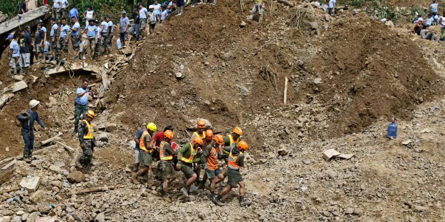 Helfer tragen die Leiche eines Opfers des Erdrutsches in Itogon (PHL), ausgelöst durch den Taifun «Mangkhut».