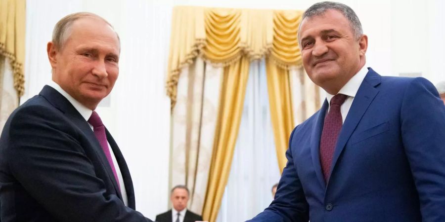 Wladimir Putin (l.), Präsident von Russland, und Anatoli Bibilow, der Präsident von Georgiens abtrünniger Region Südossetien, geben sich die Hand während ihres Treffens im Kreml in Moskau.