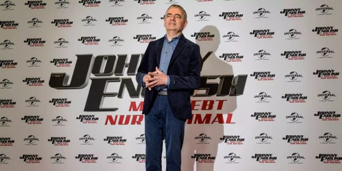Rowan Atkinson, britischer Schauspieler, steht im Hotel The Fontenay in Hamburg vor einer Wand die den Schriftzug seines neuen Films «Johnny English – Man lebt nur dreimal» trägt.