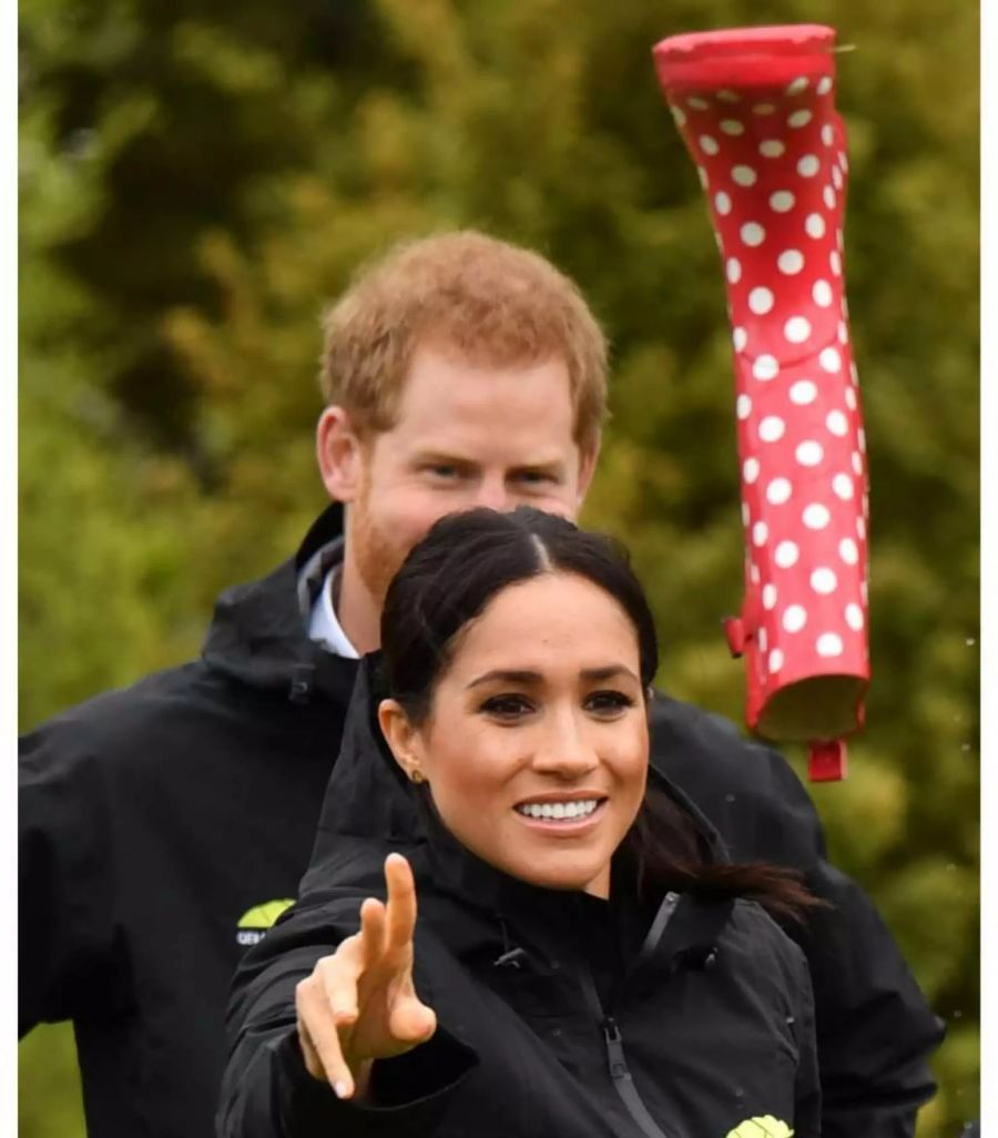 Der britische Prinz Harry (hinten), Herzog von Sussex, und seine Frau Meghan, Herzogin von Sussex, nehmen an einem «Welly Wanging»-Wettbewerb, einem Gummistiefel-Wurf-Wettbewerb, teil.