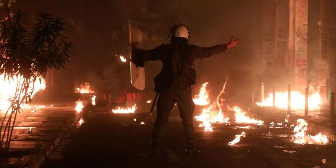Ein Polizist hebt die Hände, als vermummte Jugendliche Benzinbomben werfen bei Krawallen zum Jahrestag der blutigen Niederschlagung der Studentenrevolte gegen die damalige Militärdiktatur in Griechenland. Ein Polizist hebt die Hände.