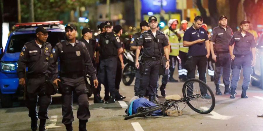 Polizisten stehen neben einem Mann, der in der Nähe des Maracana Stadiums in Rio de Janeiro erschossen wurde.