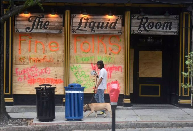 Ein Mann vor einem verbarrikadierten Laden in Wilmington, North Carolina. In den betroffenen Regionen werden letzte Vorbereitungen getroffen. Ein Mann vor einem verbarrikadierten Laden in Wilmington, North Carolina. In den betroffenen Regionen werden letzte Vorbereitungen getroffen.