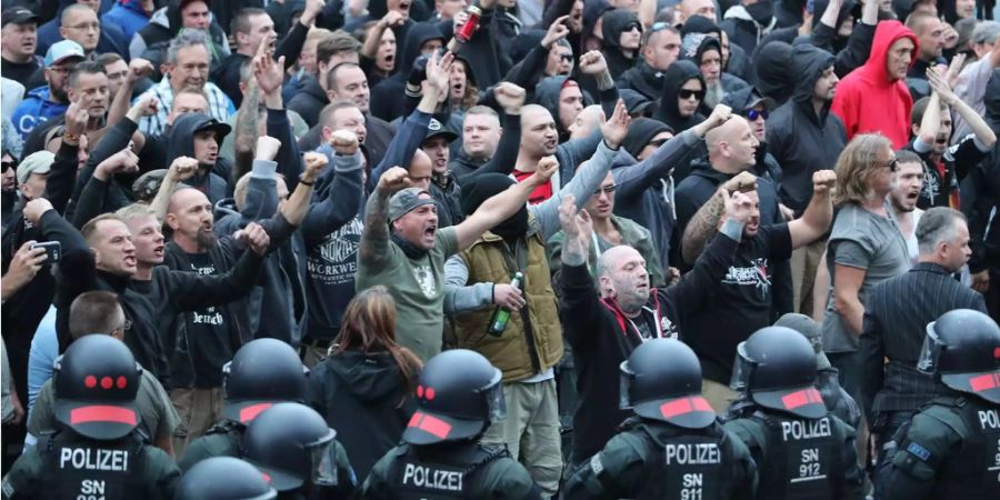 Polizisten stehen in der Innenstadt am Karl-Marx-Monument bei einer Kundgebung der rechten Szene, um ein Aufeinanderprallen von rechten und linken Gruppen zu verhindern.