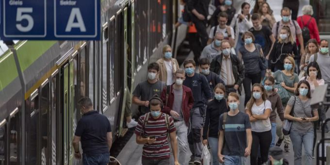 Zugsreisende mit Schutzmasken verlassen einen Zug während der Corona-Pandemie am Montag, 6. Juli 2020 im Bahnhof Luzern. Pendler Luzern