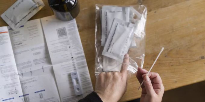 Eine Frau macht einen Coronavirus Antigen-Selbsttest mit Nasenabstrich bei sich zu Hause. Selbsttest roche coronavirus