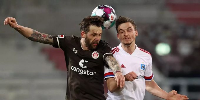 Guido Burgstaller von FC St. Pauli und Hamburgs Moritz Heyer (r) kämpfen um den Ball. HSV