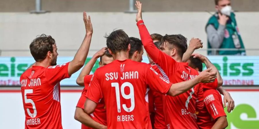 Die Mannschaft von Regensburg jubelt nach dem Treffer zum 1:0 gegen St. Pauli. Foto: Armin Weigel/dpa