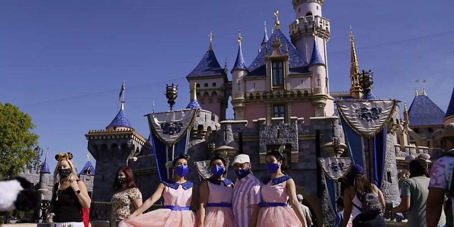 Eine Familie macht ein Foto vor dem Dornröschenschloss im Disneyland. Foto: Jae Hong/AP/dpa