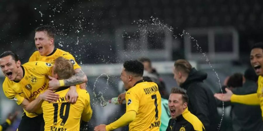 Dortmunds Spieler feiern den Pokalsieg nach Abpfiff. Foto: Michael Sohn/AP-Pool/dpa